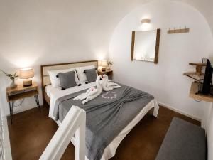 a bedroom with a bed with a stuffed animal laying on it at Mare Nostrum Santo in Oia +79 photos