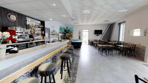 a restaurant with a bar with chairs and tables at Hotel restaurant LAISSAC SPEISER in Olargues