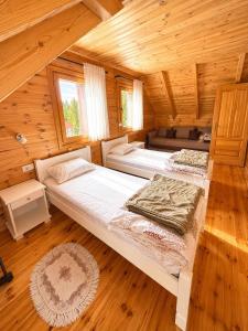 a bedroom with two beds in a wooden cabin at Chalet Aleksa in Žabljak
