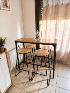 a wooden table and stools with a glass bowl on top at Studio cosy Valras, plage à 20 m in Valras-Plage