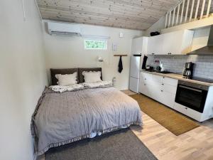 a bedroom with a large bed and a kitchen at Central, Modern, Cozy Cottage in Gävle
