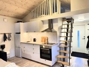 a kitchen with white cabinets and a spiral staircase at Central, Modern, Cozy Cottage in Gävle +25 photos