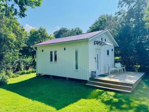 a small white shed with a deck in a yard at Central, Modern, Cozy Cottage in Gävle