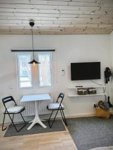 a living room with a table and two chairs and a tv at Central, Modern, Cozy Cottage in Gävle