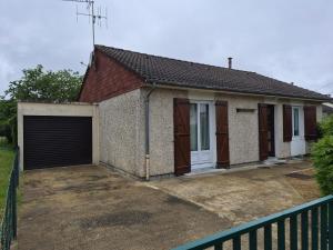 a small brick house with a garage at Les pins in Mulsanne