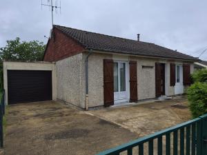 a small house with a garage and a fence at Les pins in Mulsanne