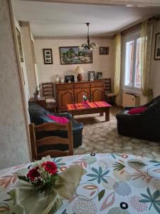 a living room with a table and a couch at Les pins in Mulsanne +1 photo
