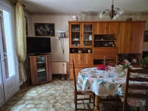 a dining room with a table and a television at Les pins in Mulsanne