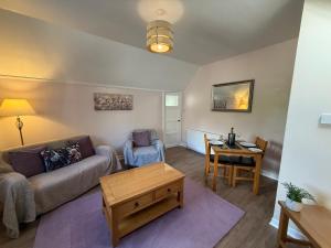 a living room with a couch and a table at Willows Cottage in Pitlochry