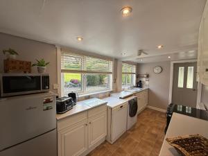 a kitchen with a refrigerator and a dishwasher at Willows Cottage in Pitlochry