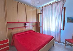 a bedroom with a red bed with a red blanket at Residence Antonella in Capoliveri