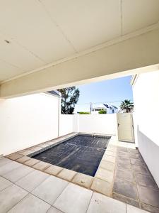 an empty room with a white wall and a pool at Bluebay Villa in Britannia Bay