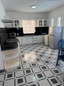 a kitchen with black and white tile floors and appliances at Coco villa in Flic-en-Flac