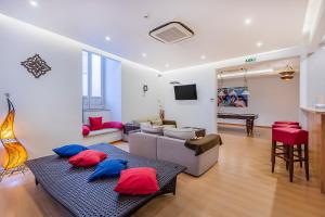 a living room with red and blue pillows on a couch at HI Tavira – Pousada de Juventude in Tavira