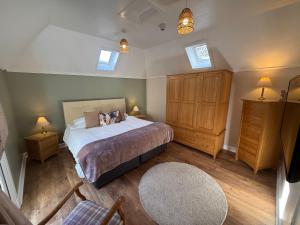 a bedroom with a bed with two night stands and two windows at Willows Cottage in Pitlochry