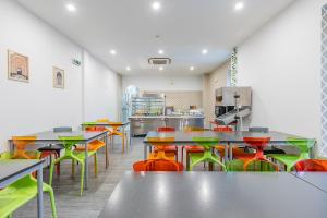 a cafeteria with tables and colorful chairs at HI Tavira – Pousada de Juventude in Tavira