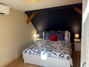 a bedroom with a bed with a red pillow on it at S'Nekel Hisel - Gîte à Offwiller in Offwiller +30 photos