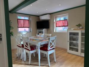 a dining room with a white table and chairs at S'Nekel Hisel - Gîte à Offwiller in Offwiller