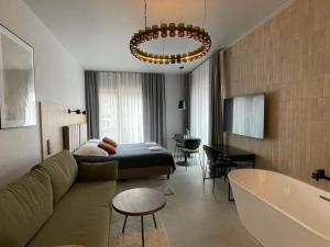 a living room with a couch and a bed and a tub at Dobry Browar in Gniezno