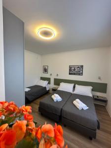 two beds in a room with orange flowers at B&B Piano B in Riva del Garda +34 photos