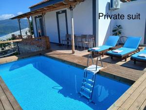 a swimming pool with a ladder next to a house at Emiljano Seaview in Ksamil