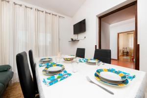 a dining room with a white table and chairs at Enjoy & Relax Da Elvia in Rovinj
