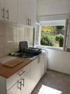 a small kitchen with a sink and a window at Guest House Life in Neum