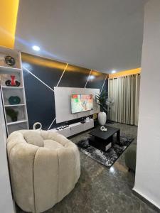 a living room with a couch and a flat screen tv at Kennys place in Isaga-Abosule