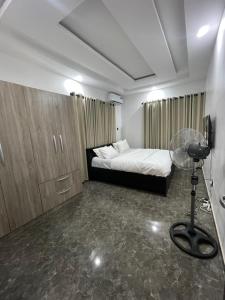 a room with a bed and a fan in it at Kennys place in Isaga-Abosule