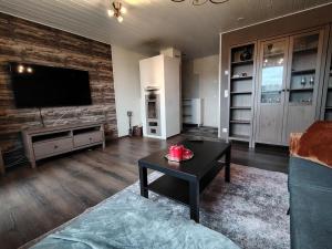 a living room with a couch and a table and a tv at Faamos Loviisa in Loviisa