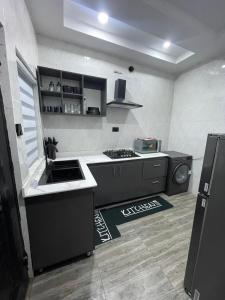 a kitchen with a sink and a stove in it at Kennys place in Isaga-Abosule +13 photos