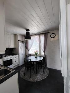 a kitchen with a table and chairs in a kitchen at Faamos Loviisa in Loviisa