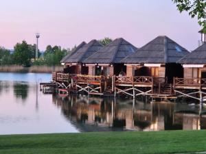 a group of wooden huts on the water at Domček na vode 6 in Senec