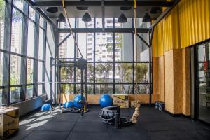 a gym with blue equipment in a large room with windows at Opus Gyro Vaca Brava Studio Luxo e Aconchego in Goiânia