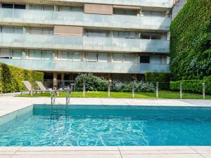 a swimming pool in front of a building at Lezama Park in Buenos Aires