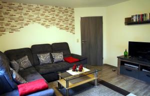 a living room with a couch and a television at "Am Waldesrand" RE16 in Sögel +10 photos