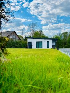 a white house sitting on top of a lush green field at Casuta cu ciubar Valea Avrigului - Secret Forest in Avrig