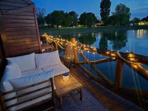 a deck with a couch and lights on the water at Domček na vode 6 in Senec