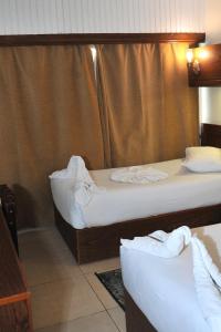 zwei Betten in einem Hotelzimmer mit Handtüchern in der Unterkunft Salma Hotel in Kairo