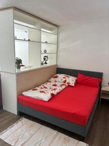 a bedroom with a bed with red sheets and a window at Pension Hutterer in Scharnstein