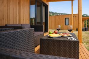a table with a plate of fruit and wine glasses at Cabañas Compostela - Cabaña Bosque Encantado in Santiago de Compostela