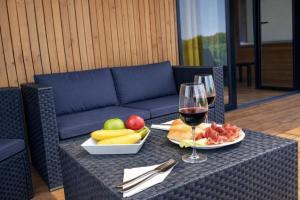 a table with a plate of fruit and a glass of wine at Cabañas Compostela - Cabaña Bosque Encantado in Santiago de Compostela