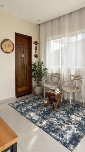 a living room with two chairs and a table and a door at Chalé Arandu in Santo Amaro