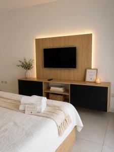 a bedroom with a flat screen tv and a bed at Lezama Park in Buenos Aires +17 photos