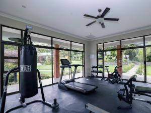 a gym with several tread machines and a punching bag at Pitzer Suites in Midrand +9 photos