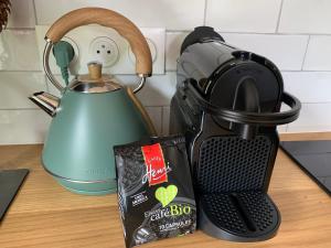 a tea kettle and a bag of chocolate on a counter at Éco-Gîte "La Chouette Verte" - Eco-Lodge "The Green Owl" in Wangenbourg