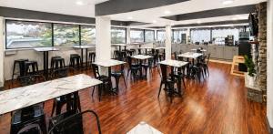 a restaurant with wooden floors and tables and chairs at The View Inn & Suites Bethlehem / Allentown / Lehigh Airport in Bethlehem