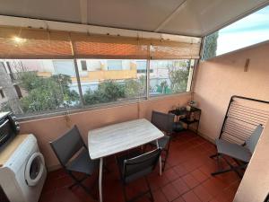 a table and chairs in a room with a window at Vacances Cap d'Agde 1 chambre, 1 mezzanine, parking et piscine in Cap d'Agde +3 photos