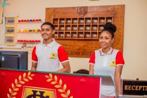 two people standing behind a counter in a store at Salama Hôtel Majunga in Mahajanga