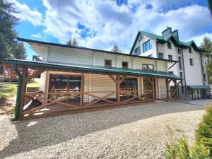 a large house with a large wooden building at Отель MONBLAN in Yablunytsya